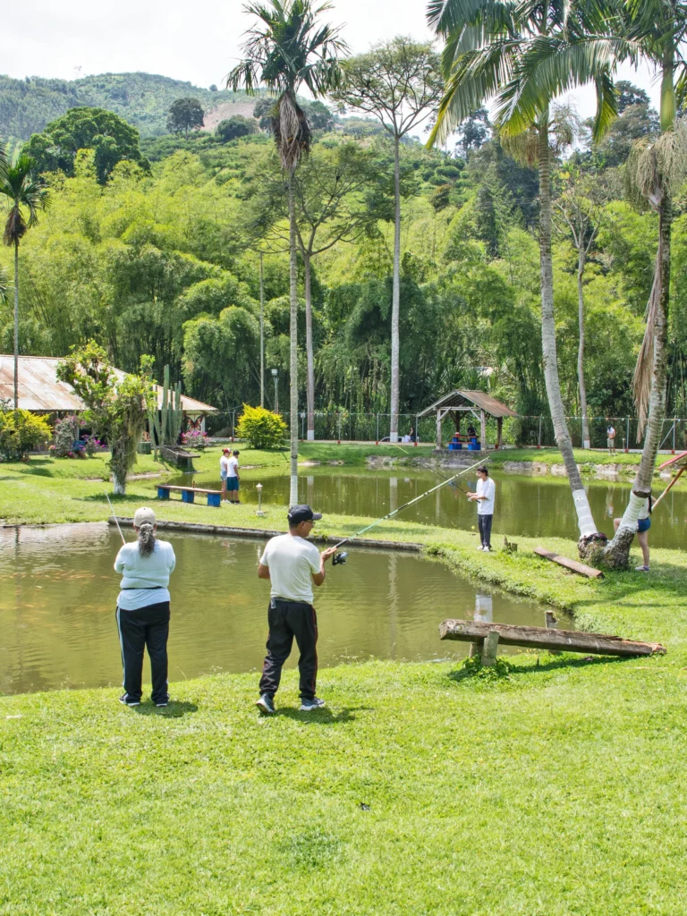 Personas practicando pesca deportiva en el lago natural del Restaurante Los Potrillos de Yoli, Marsella, Risaralda.