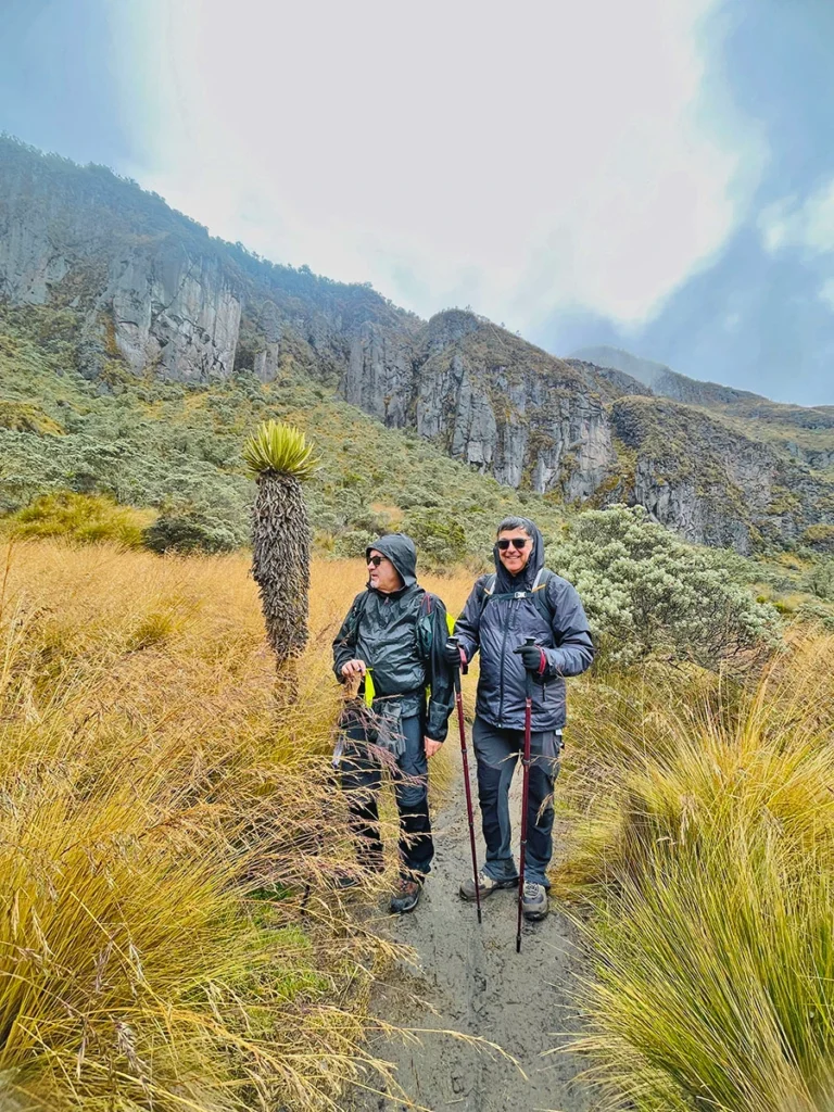 Montañistas recorriendo el Sendero del Cambio Climático rodeados de niebla y vegetación de páramo en el Nevado de Santa Isabel con Inturviajes.