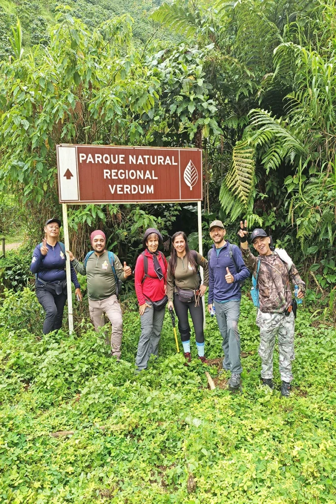 Grupo de excursionistas en la entrada del Parque Natural Regional Verdum en Risaralda, participando en una jornada de senderismo guiado