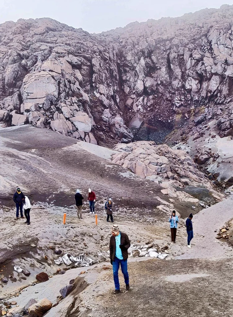 Grupo de excursionistas recorriendo la zona rocosa y el terreno de morrena en la base del Nevado de Santa Isabel con Colombian Adventure.