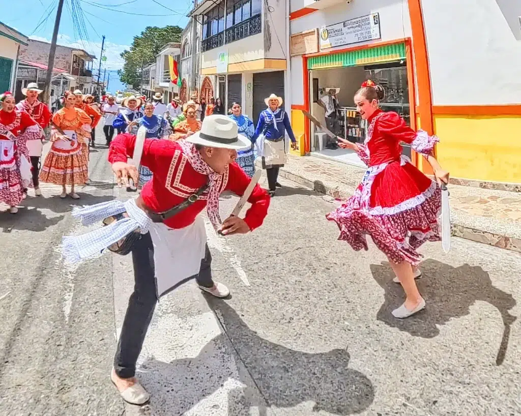 Pareja de bailarines con trajes típicos campesinos realizando la danza del machete en las Fiestas Folclóricas de Quinchía.