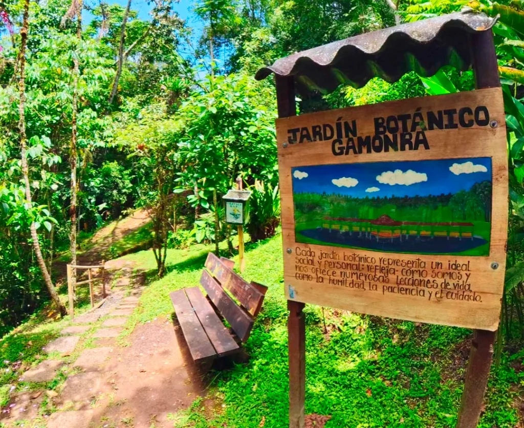 Letrero de bienvenida en madera y sendero interpretativo del Jardín Botánico Gamonrá en Guática, Risaralda.