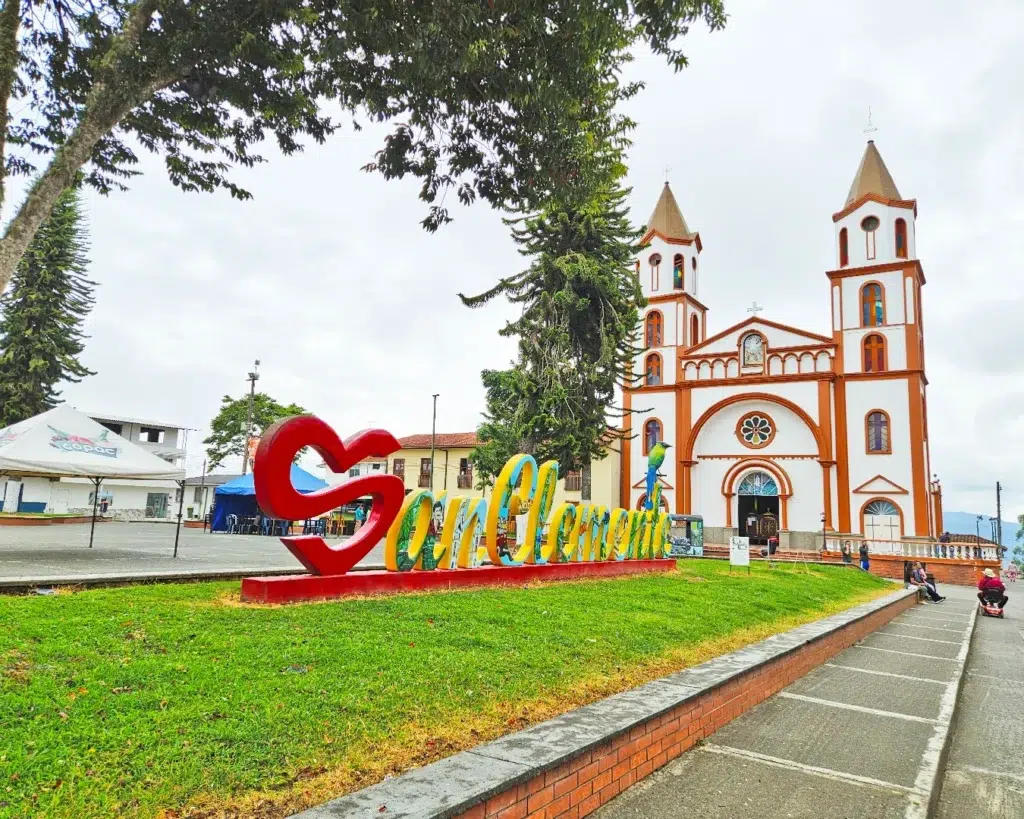 Santuario de Nuestra Señora de Fátima y letrero turístico en la plaza principal de San Clemente, Guática, Risaralda.