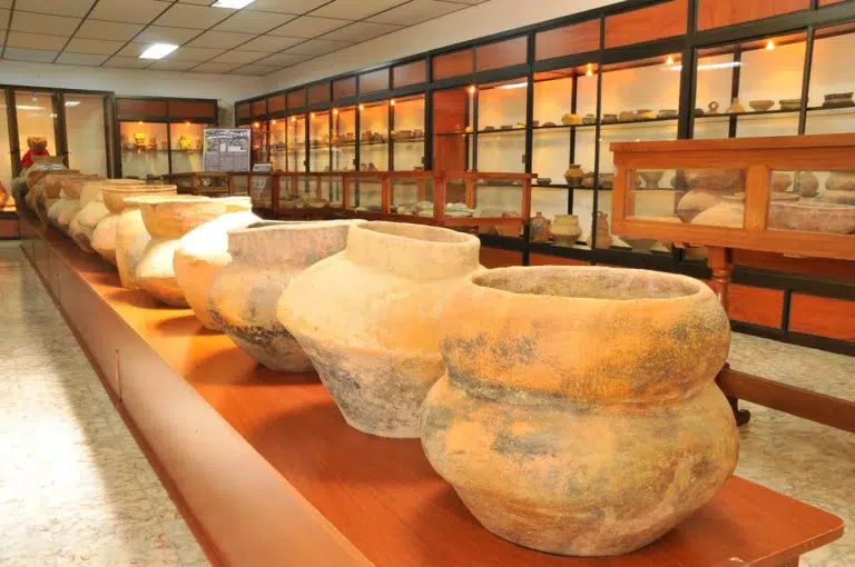 Vasijas de barro y piezas arqueológicas precolombinas exhibidas en vitrinas de un museo en Guática.