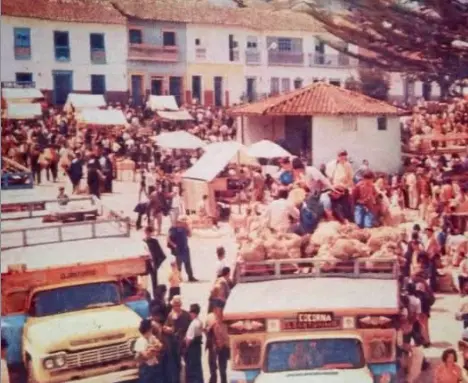 Fotografía histórica de la plaza de mercado de Santuario Risaralda con chivas tradicionales y campesinos comerciando productos.